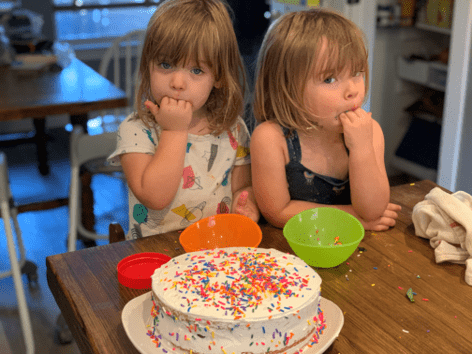 toddler girls licking sprinkles off their fingers