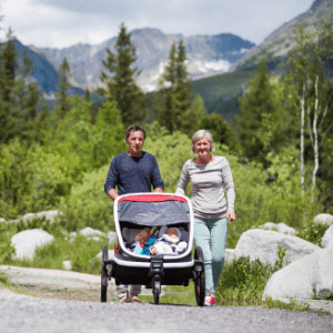 couple pushing double stroller on gravel