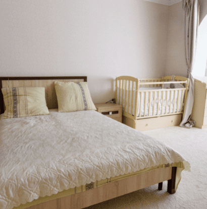 bed with a crib in a corner