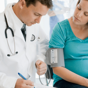 pregnant woman and doctor writing in chart