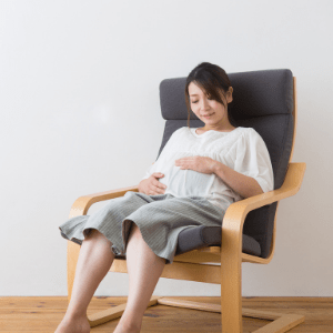 pregnant woman sitting in chair and holding belly