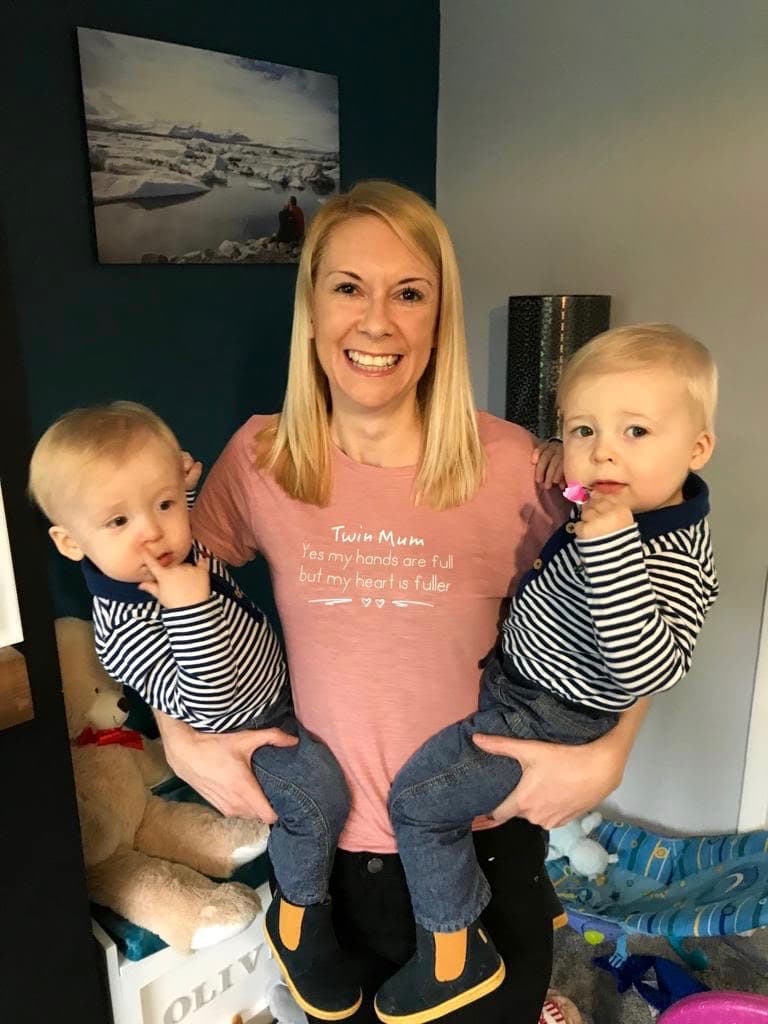 a woman holding twins on each hip