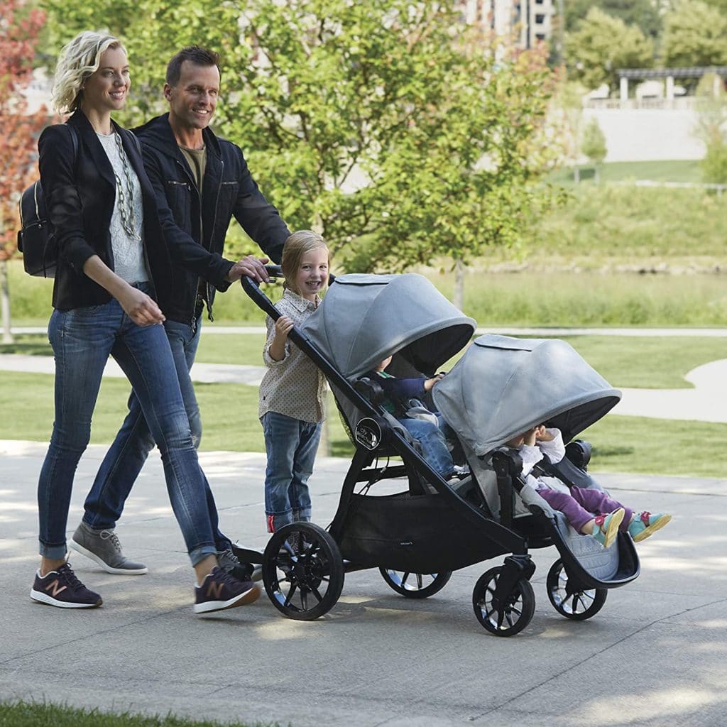 a couple with 3 children pushing a stroller