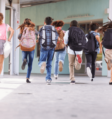 Kids running into school with backpack on