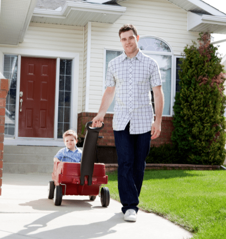 man pulls a child in a red wagon