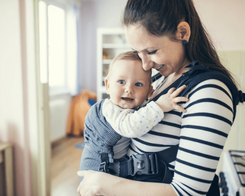 mom smiling at baby in front carrier