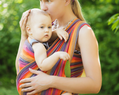 mom holding baby in a wrap carrier