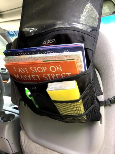 car seat organizer filled with books and a pencil case