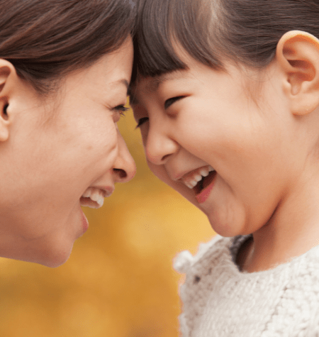 mom and girl faces smiling at each other