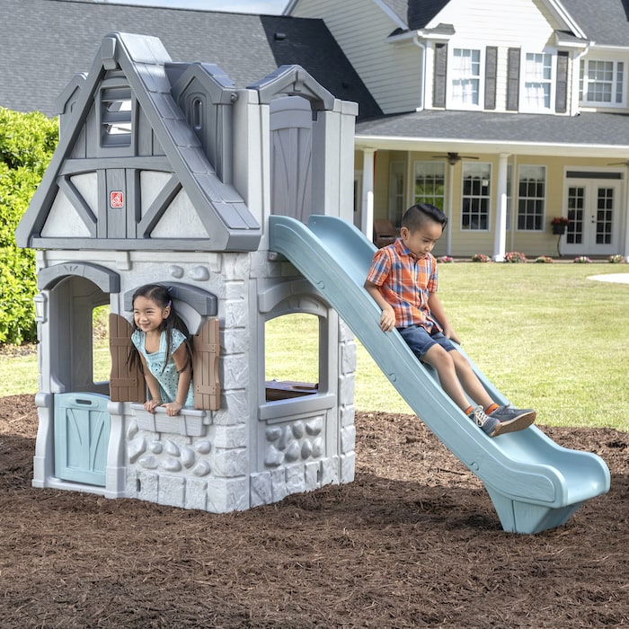 kids playing on a 2-story playhouse by step2