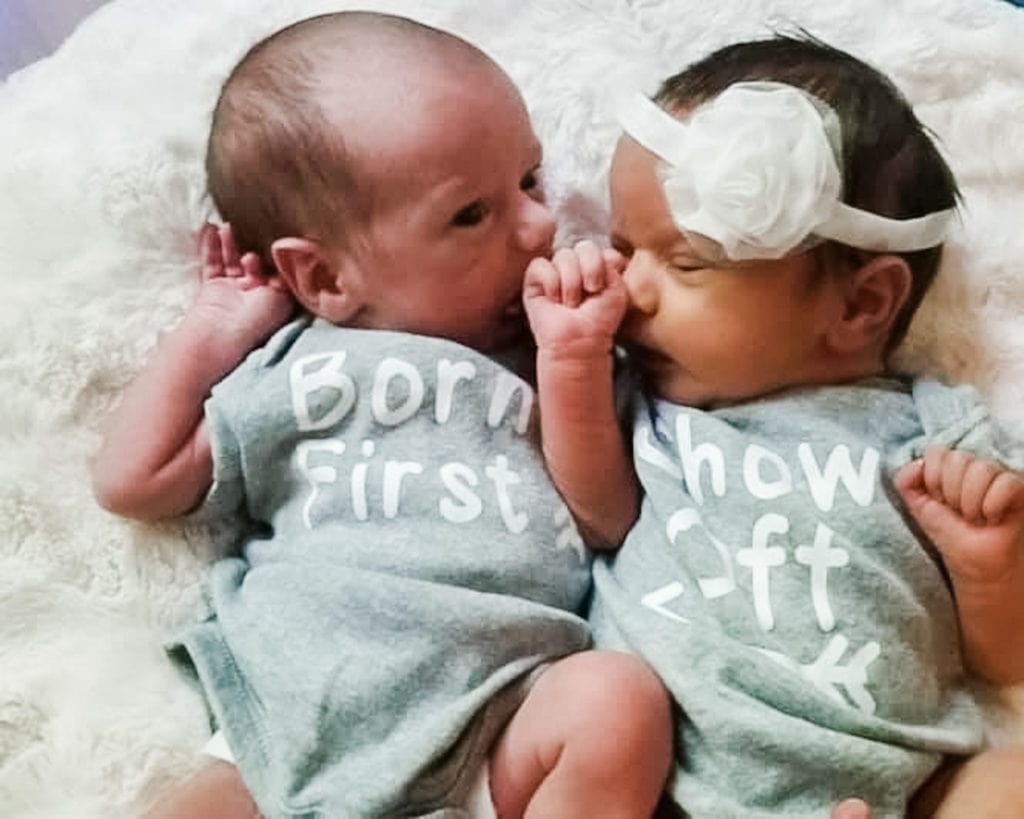 newborn boy girl twins laying on a bed