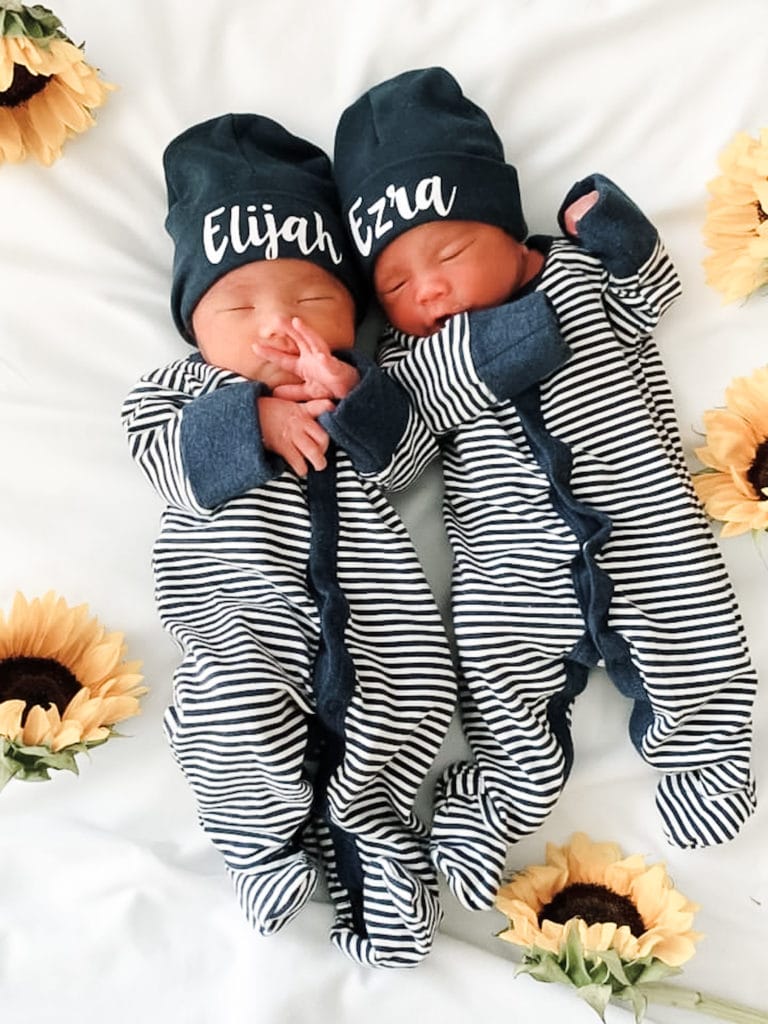 twin baby boys in matching pajamas with hats