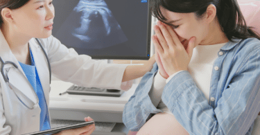 a pregnant woman cries at the doctor's office after an ultrasound