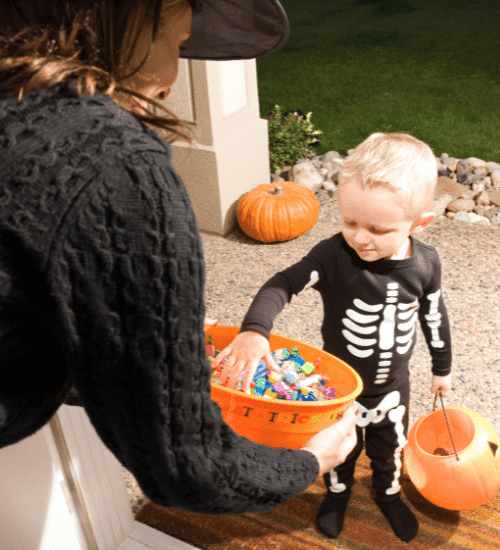 little kid taking candy from bowl trick or treating