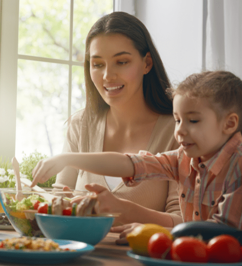 mom and daughter with a salad at a table