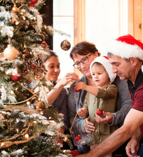 family decorating a christmas tree together