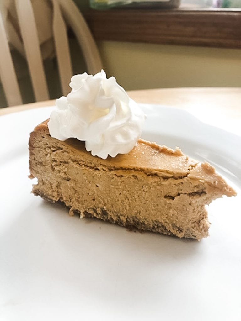 sliced pumpkin pie cheesecake with whipped cream