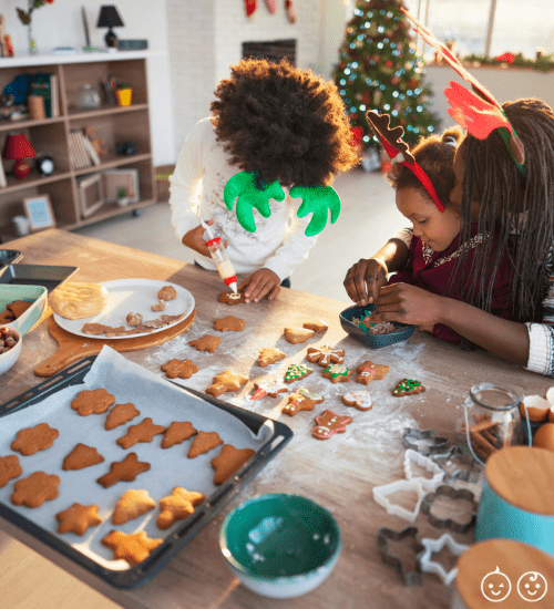 kids and mom decorating cookies during the holiday season