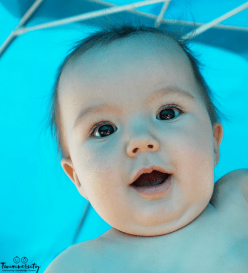 baby under a blue umbrella to promote baby skin care in the sun