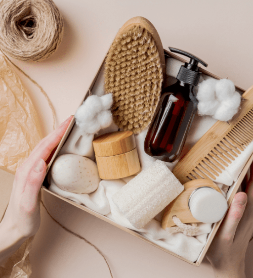 box filled with cotton balls, comb, brush, loofah and misc. grooming items with twine