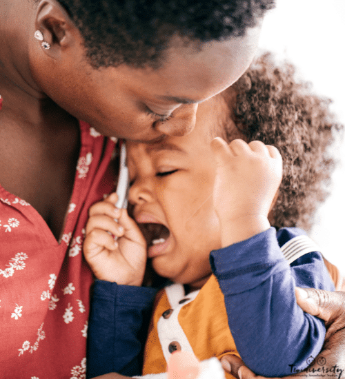 toddler boy in his mom's arms having a tantrum, crying