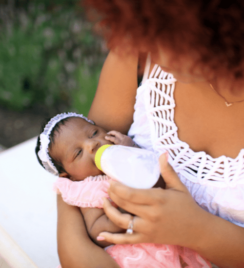 woman feeding a newborn baby with a bottle