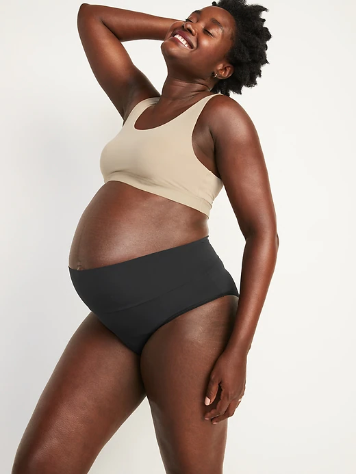 pregnant woman in black maternity underwear and tan bra