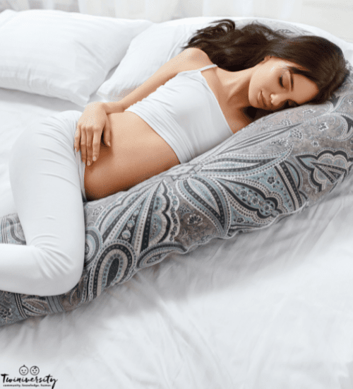 pregnant woman sleeping on her side with a pregnancy pillow that can be a twin breastfeeding pillow
