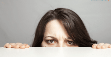 unhappy mom hiding behind the counter. Only the bridge of her nose, eyes, and forehead can be seen