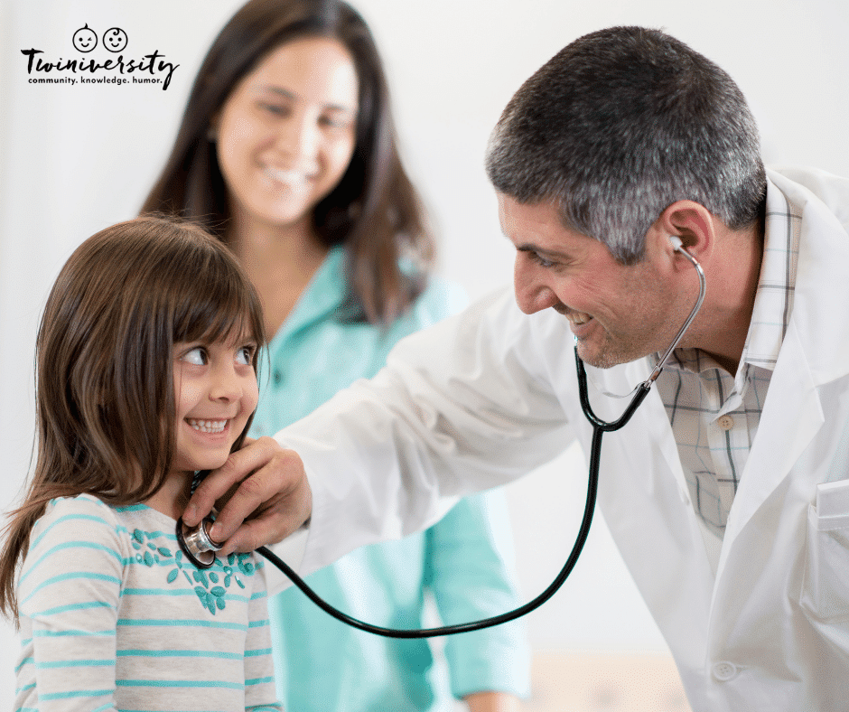 young female child being examined by doctor with stethoscope while female caretaker observes
