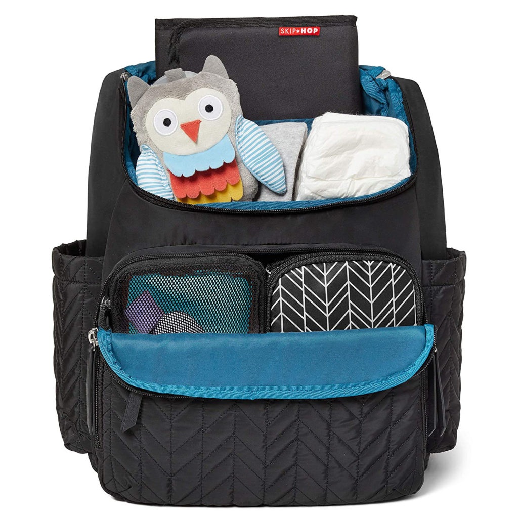 a black diaper bag with open pockets showing diapers and a stuffed owl toy plus a folded changing pad. twin baby shower gift ideas