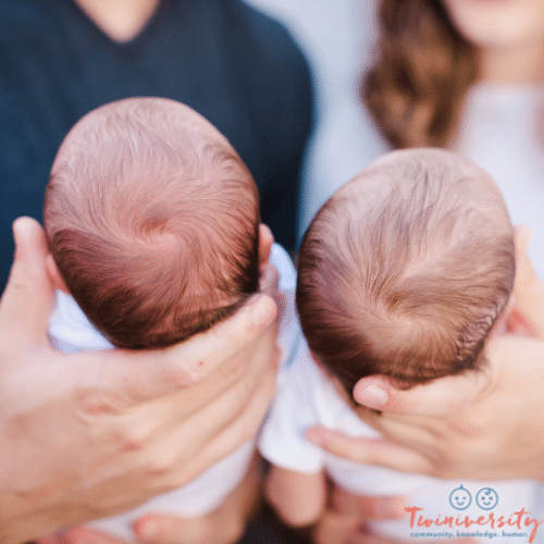 a man and woman out of focus holding two newborns, showing the tops of their heads for the cord blood giveaway post