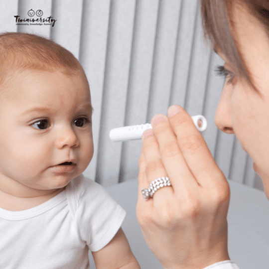 young baby having eyes examined at first pediatric eye doctor visit