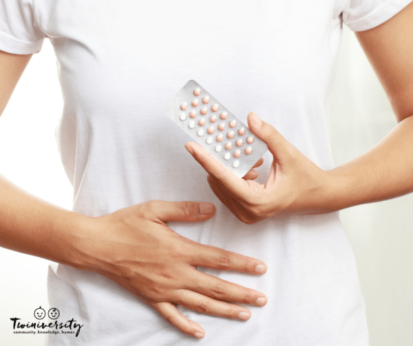 woman holds package of birth control pills in front of stomach