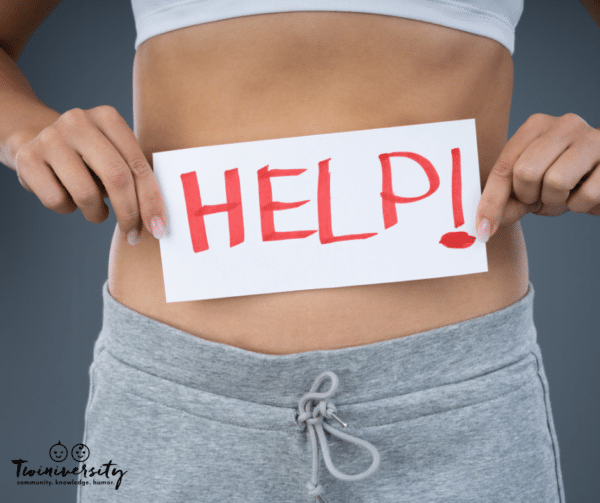 woman with stomach pain signaling she needs help with help written on a piece of paper