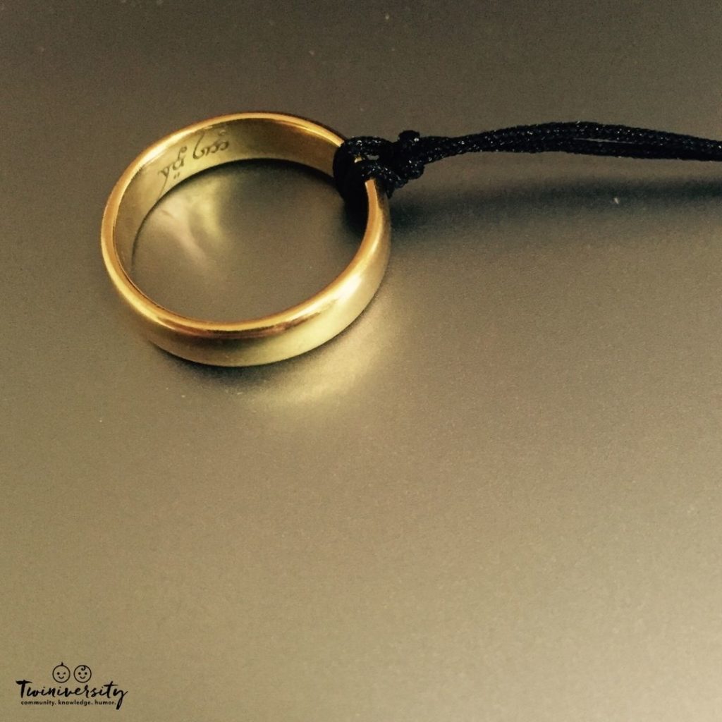 Gold wedding ring with a black string looped around it.
