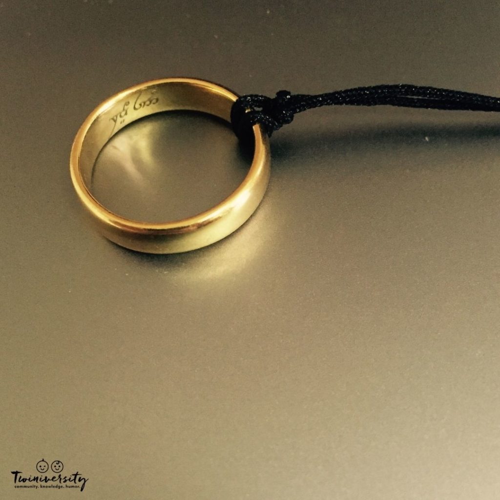 Gold wedding ring with a black string looped around it. 