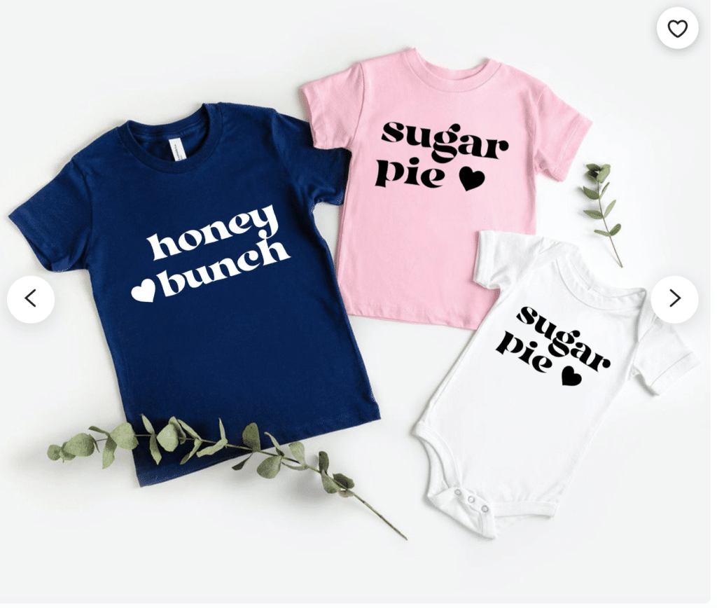 dark blue adult shirt with "honey bunch" and a small heart in white print, pink kids' shirt with "sugar pie" and a small heart in black print, white onesie with "sugar pie" and a small heart in black print