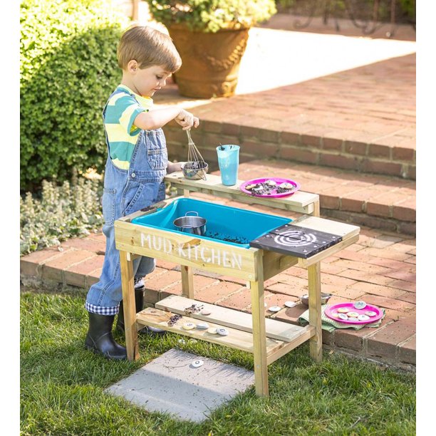 little boy playing with mud kitchen outdoor toys