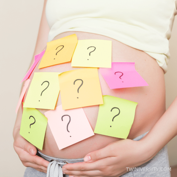 pregnant woman with question marks on post-it notes stuck to her abdomen