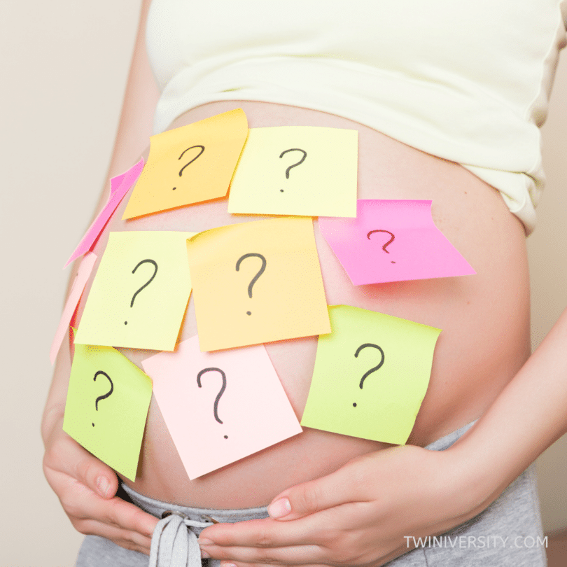 pregnant woman with question marks on post-it notes stuck to her abdomen