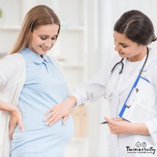 woman at a prenatal doctor's appointment with a doctor touching her abdomen