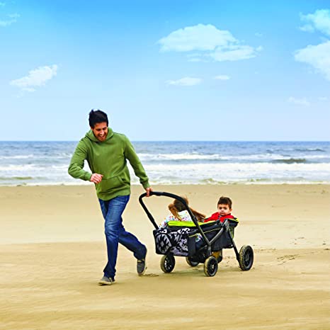 a man pulls a stroller wagon on a beach