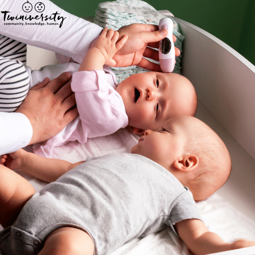 twin babies at the doctor's office getting temperature taken