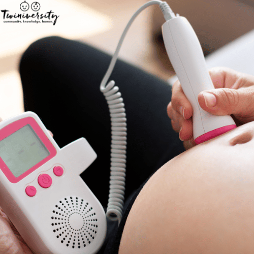 image of pregnant woman using an at-home doppler to listen to twins' heartbeats