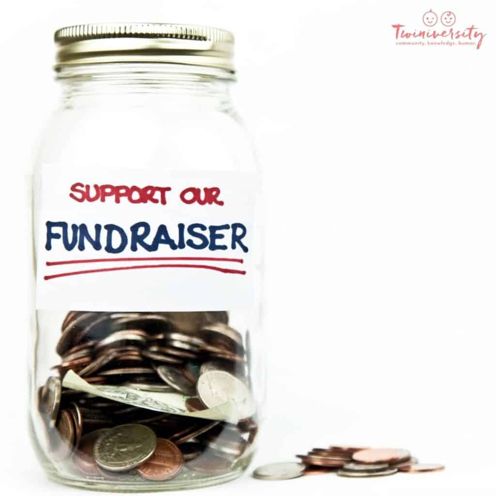 A mason jar full of loose change with a sign on it that says "Support our Fundraiser"
