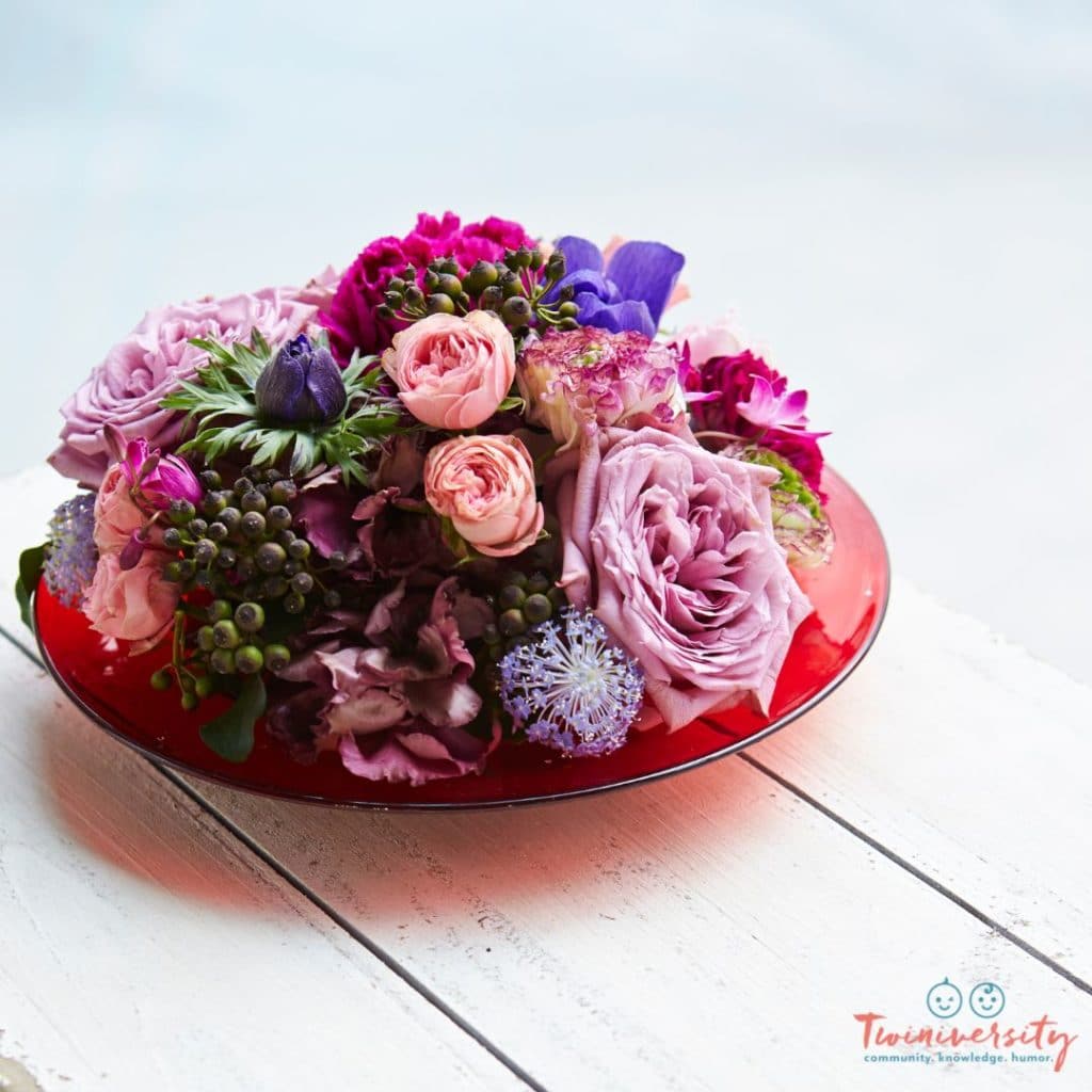 You can use flowers, like this red bowl with flowers in it, as twin shower decor