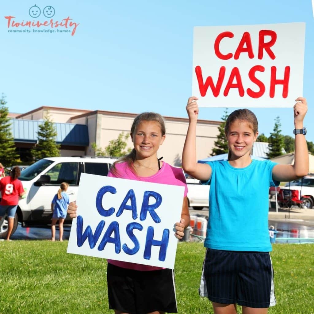 Your twins could fundraise by doing a car wash like the girls in this photo