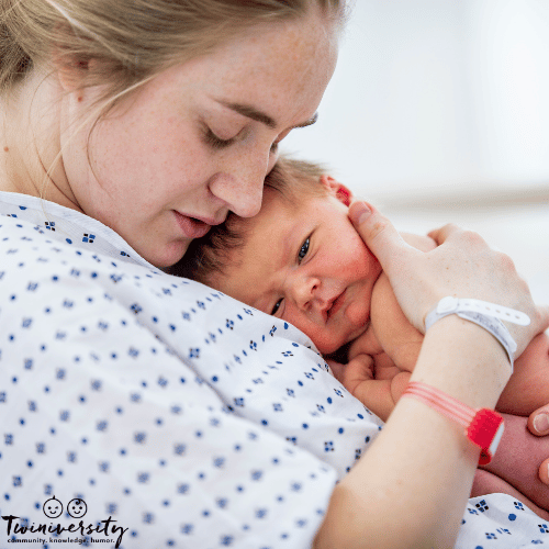 A woman holds her newborn baby in her hospital room after delivery