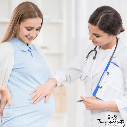 a pregnant woman is examined by a doctor on her medical care team